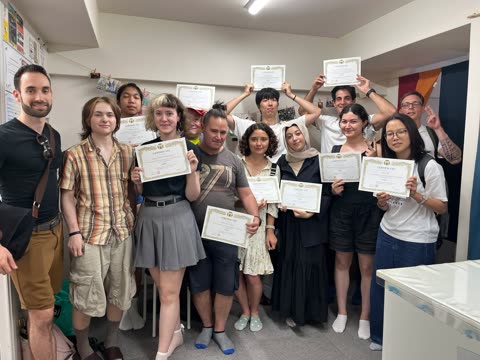 Group of people holding certificates in a room.