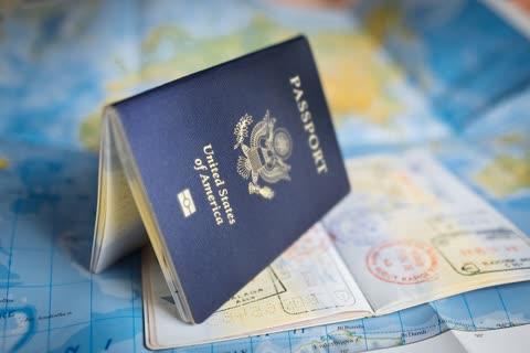 Closed US passport rests on a map with entry stamps.